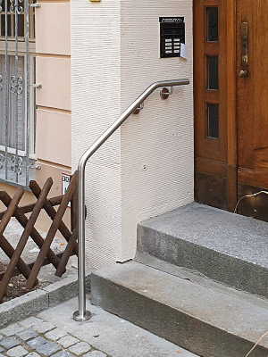 Handlauf gebogen mit einer Befestigung an der Wand und vor der Treppe